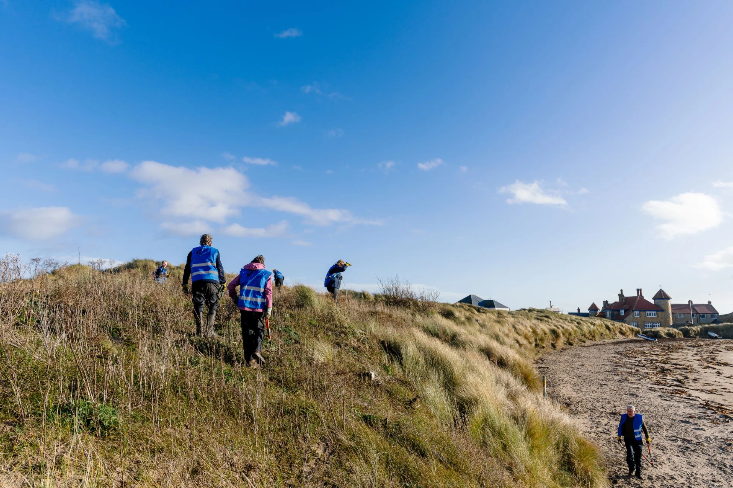 People walking along sand dunes