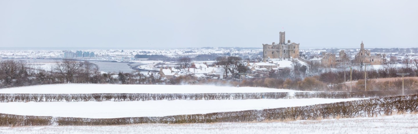 A snowy scene of Warkworth village