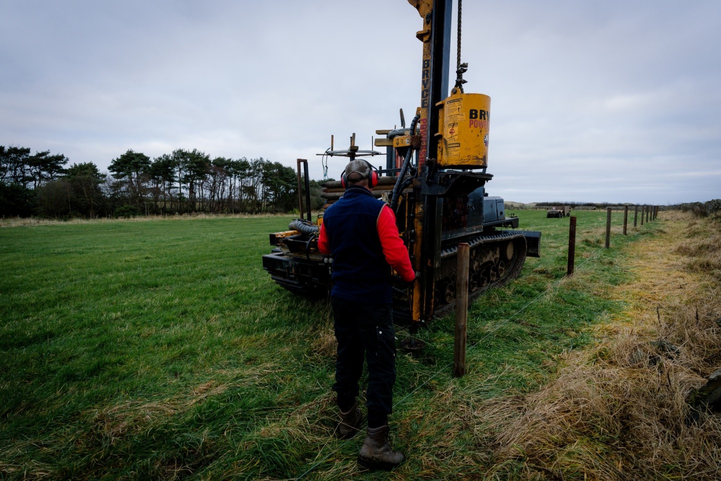 A farmer building a fence