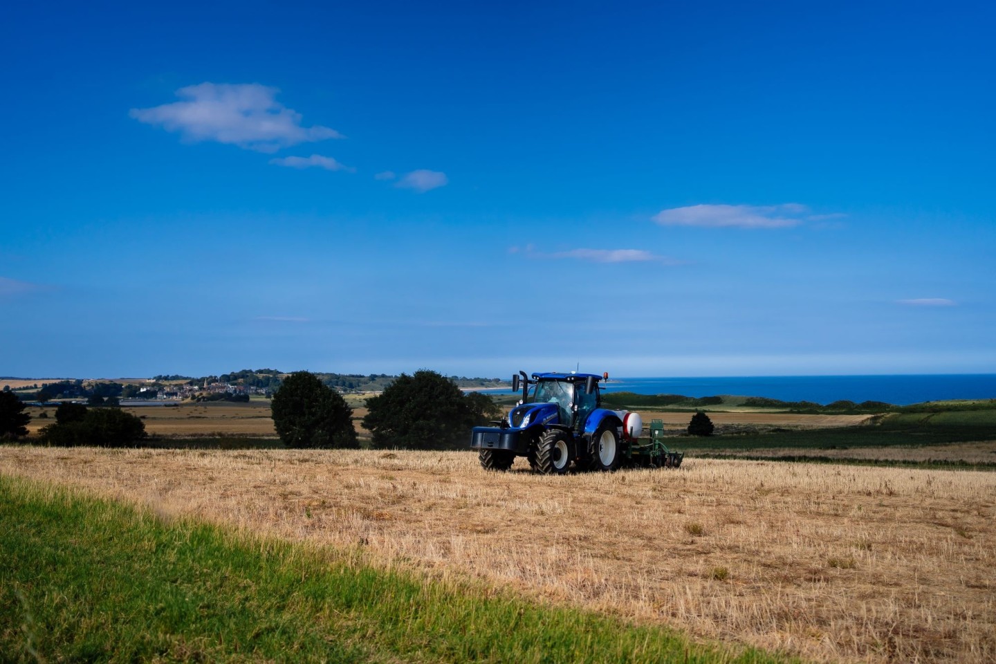 Tractor in a field with sea in the background